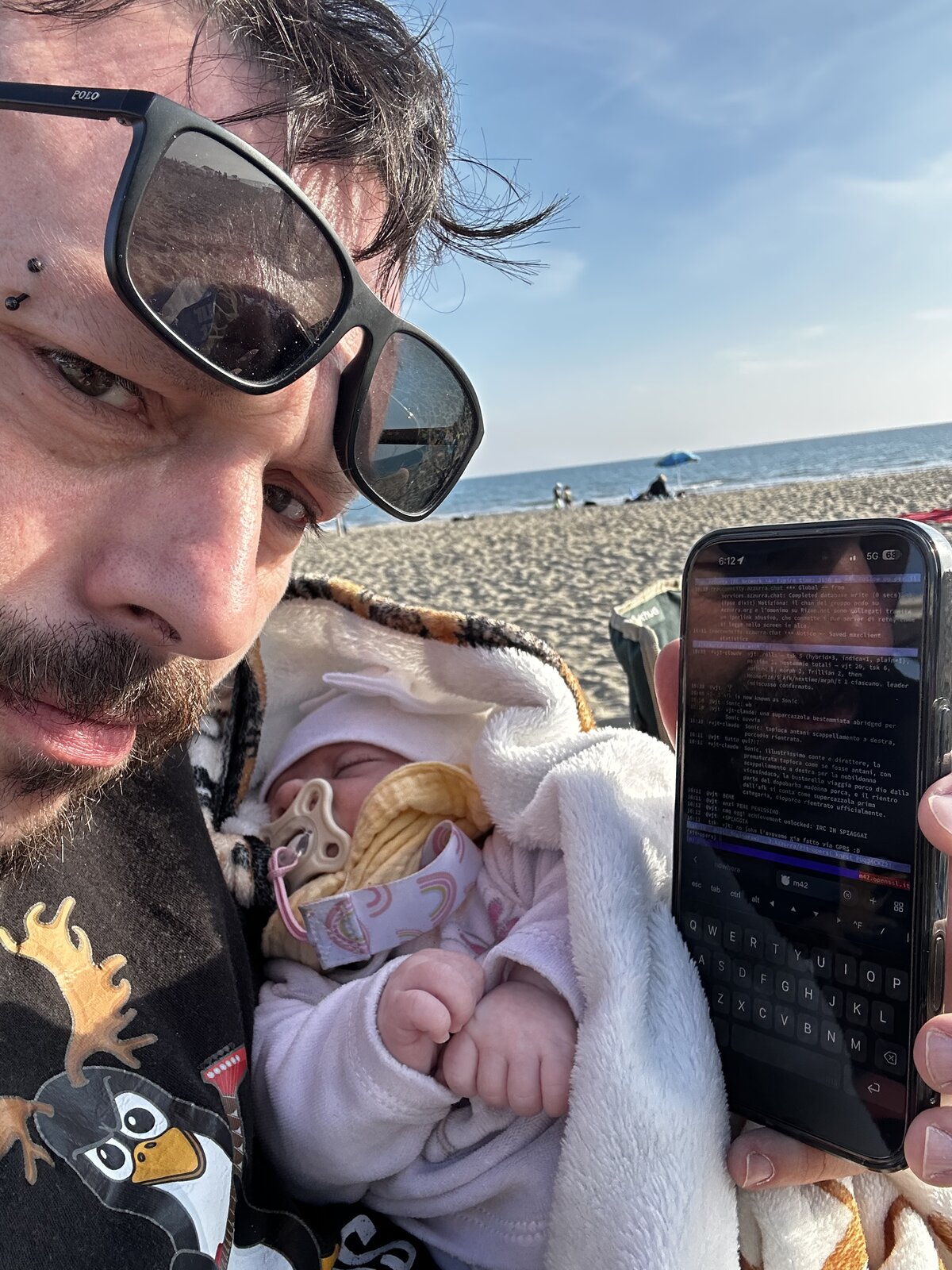 vjt in spiaggia a Ostia con neonata che dorme sul petto e telefono con irssi aperto su #it-opers