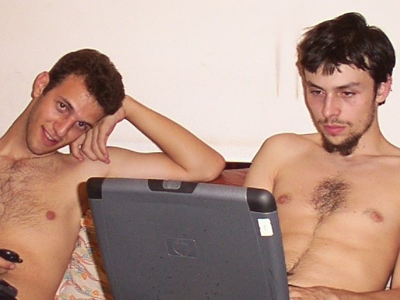 Me and tsk (Fabrizio Lanotte), exchanging data via a parallel cable (laplink) between two laptops. Shirtless, because it was summer in Southern Italy and air conditioning was for rich people. The parallel cable was faster than our internet connection.