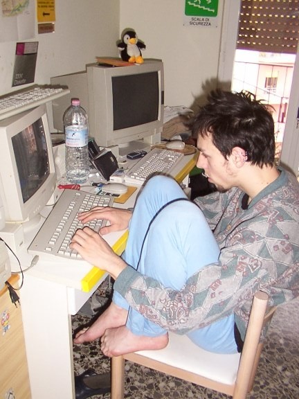 Yes, that&rsquo;s me, circa 2004. Barefoot, CRT monitors, a Linux penguin plushie, and the confidence of a 21-year-old who thought he could write better IRC services than the ones that already existed.